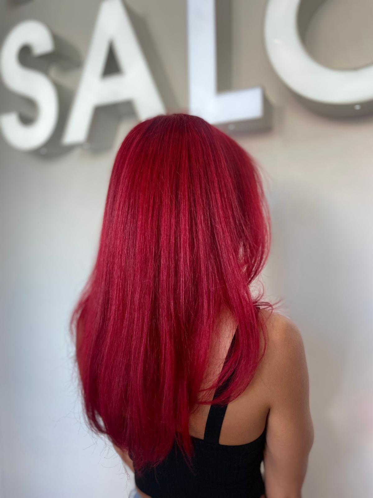 Vivid crimson color transformation in front of the Frenzy Salon sign